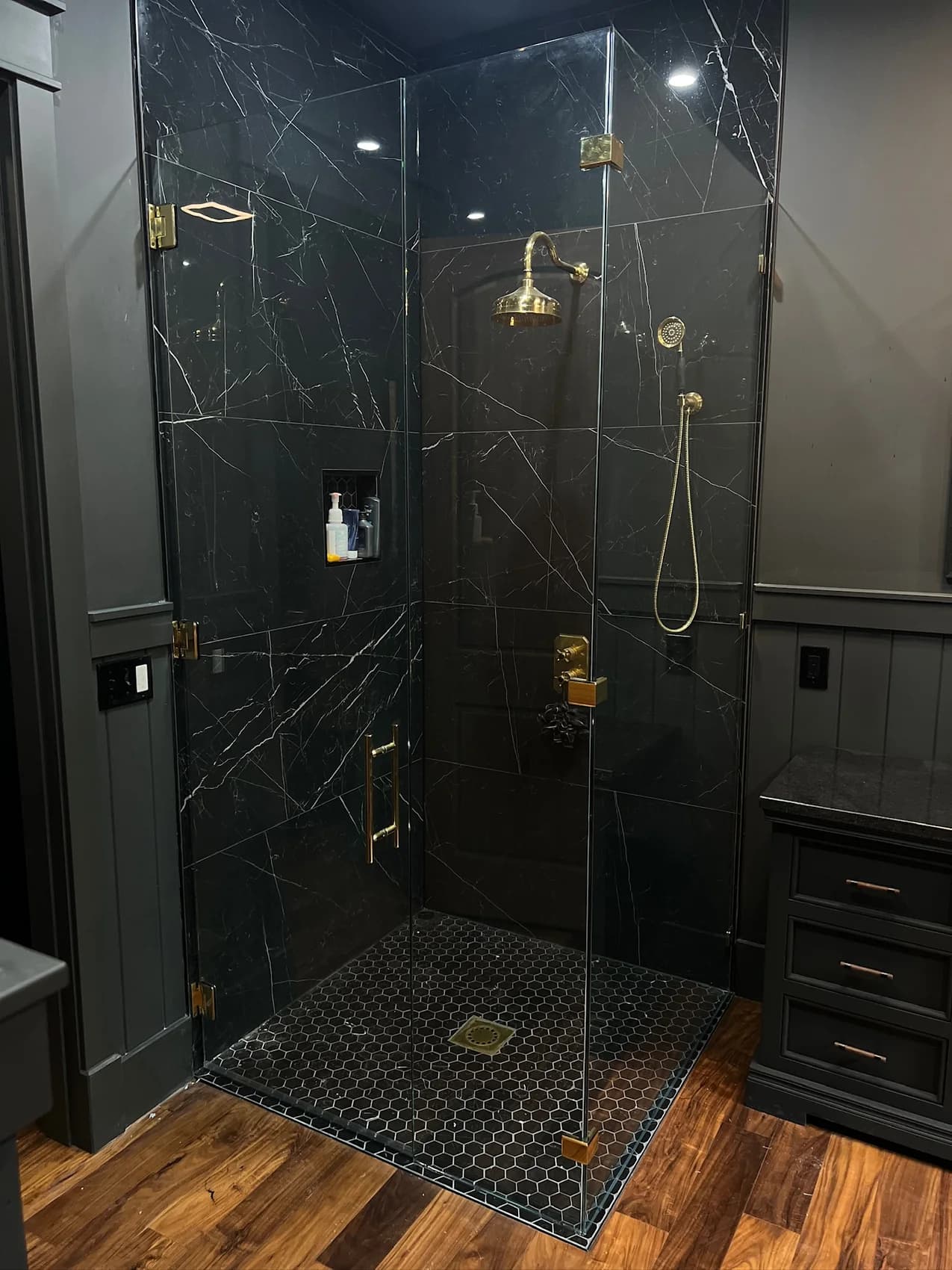 Dark tile shower with clear glass enclosure